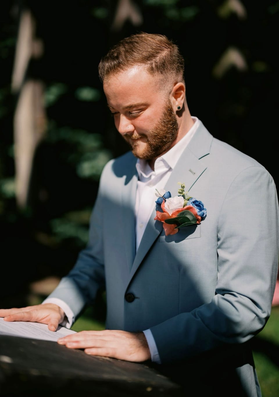 Devon Fine officiating a wedding, reading from the ceremony he wrote